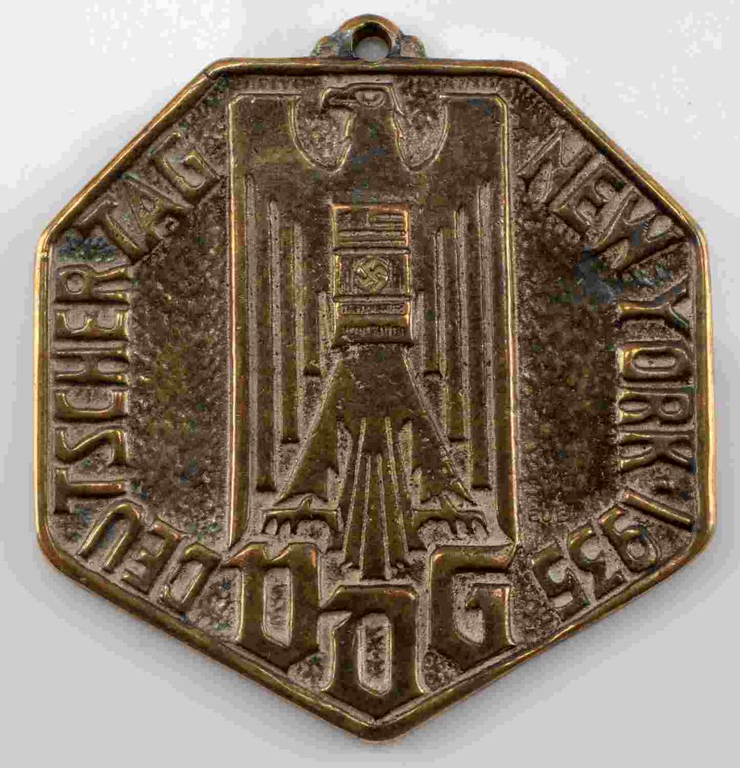 WWII GERMAN AMERICAN BUND 1935 NEW YORK VDG MEDAL: WWII German American Bund 1935 Deutscher Tag New York VDG Medal Decoration. Measures 1 5/16” wide by 1 9/16” tall. The front shows a German World War II eagle with a swastika in the center of his