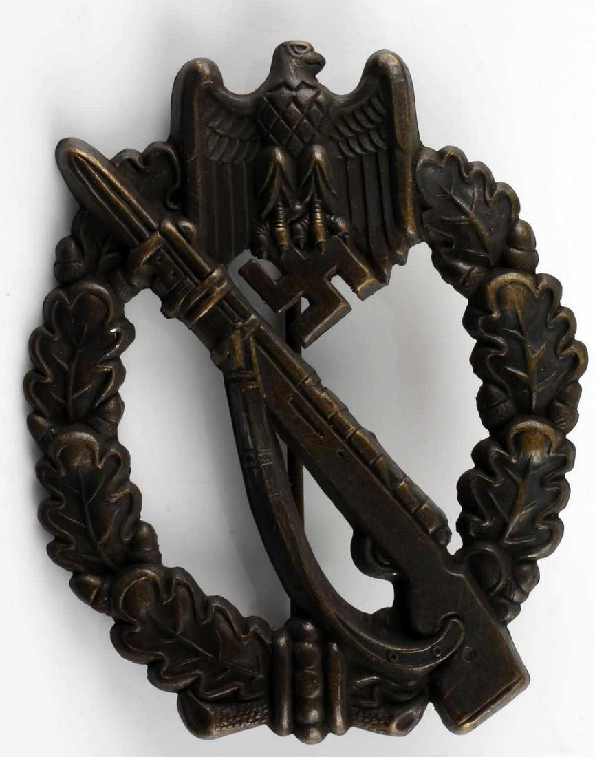 GERMAN WWII ARMY BRONZE INFANTRY ASSAULT BADGE: The front shows a Mauser K 98 rifle in the center with a German eagle clutching a swastika in his talons at the top. Both are surrounded by an oval oak leaf wreath. Has a thin vertical pin back with a
