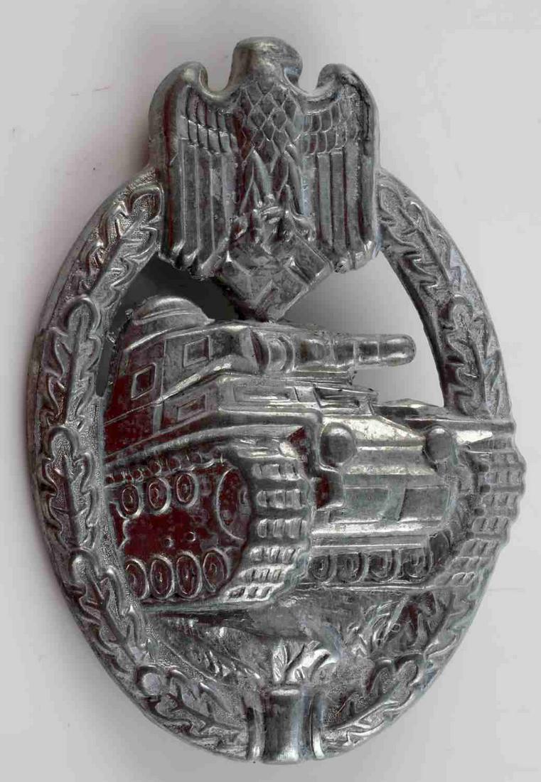 WWII GERMAN ARMY SILVER TANK ASSAULT BADGE: WWII German Army Silver Tank Assault Badge. The front shows a tank in the center with a German eagle clutching a swastika in his talons at the top. Both are surrounded by an oval oak leaf wreath. Has