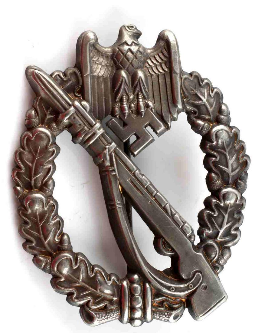 WWII GERMAN ARMY SILVER INFANTRY ASSAULT BADGE: WWII German Army Silver Infantry Assault Badge. The front shows a Mauser K 98 rifle in the center with a German eagle clutching a swastika in his talons at the top. Both are surrounded by an oval oak 