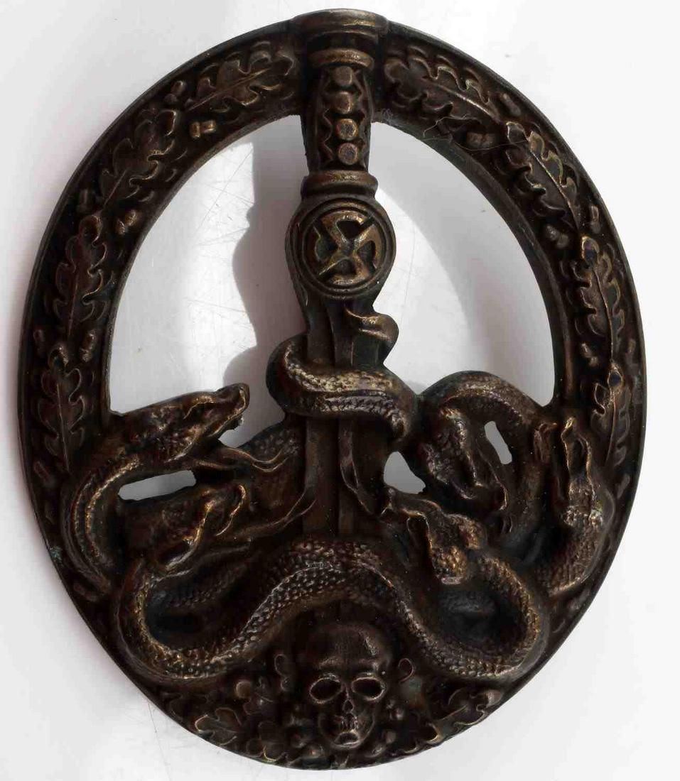 GERMAN WWII THIRD REICH ANTI PARTISAN BADGE: German WWII Army Heer Bronze Anti Partisan Badge. The front shows five snakes on the lower part wrapped around a sword blade with a skull at the base. All six are surrounded by an oval oak leaf wreath