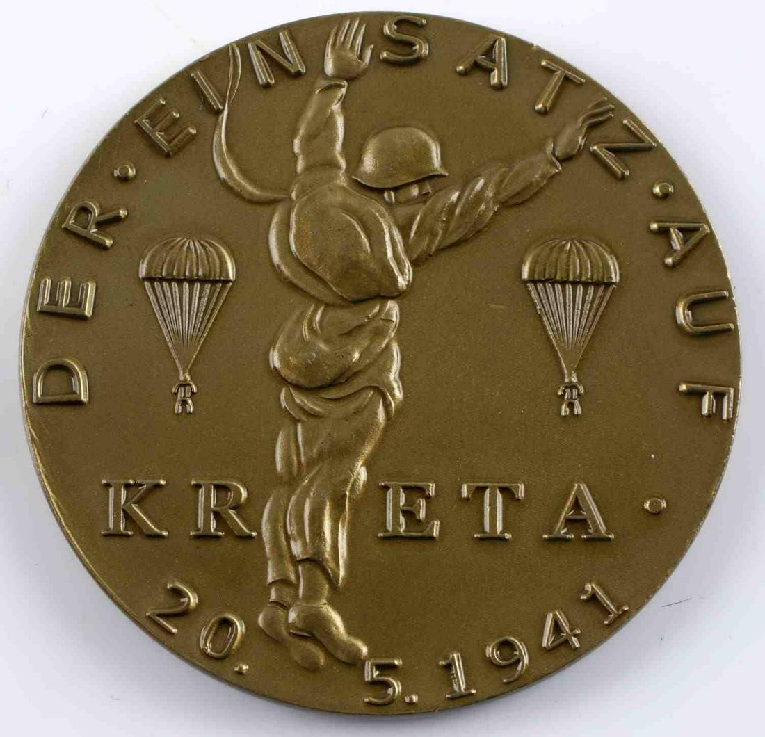 WWII GERMANY LUFTWAFFE KRETA PARATROOPER MEDAL: Measures 2 1/4" in diameter. The front reads ‘Der Ein Satz Auf KRETA 20.5.1941’. It shows three paratroopers jumping from the sky. The reverse side reads ‘Mit / JU 52 Unter – General Student��