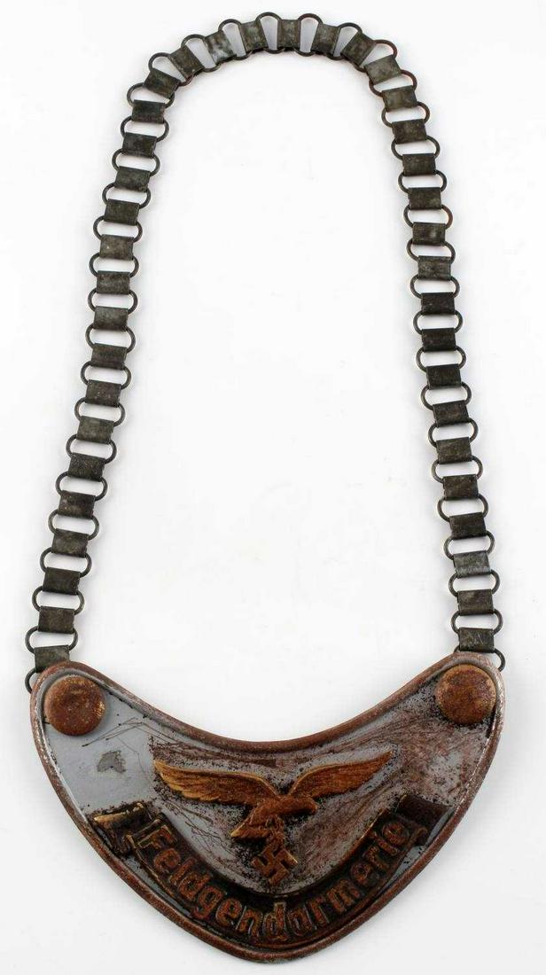 WWII GERMAN LUFTWAFFE FIELD GORGET AND NECK CHAIN: WWII German Luftwaffe Feldgendarmerie Field Gorget & Neck Chain. Measures 6 1/2" wide by 4 1/4" tall. The front reads ‘Feldgendarmerie’. It shows a Luftwaffe flying eagle clutching a swastika in h