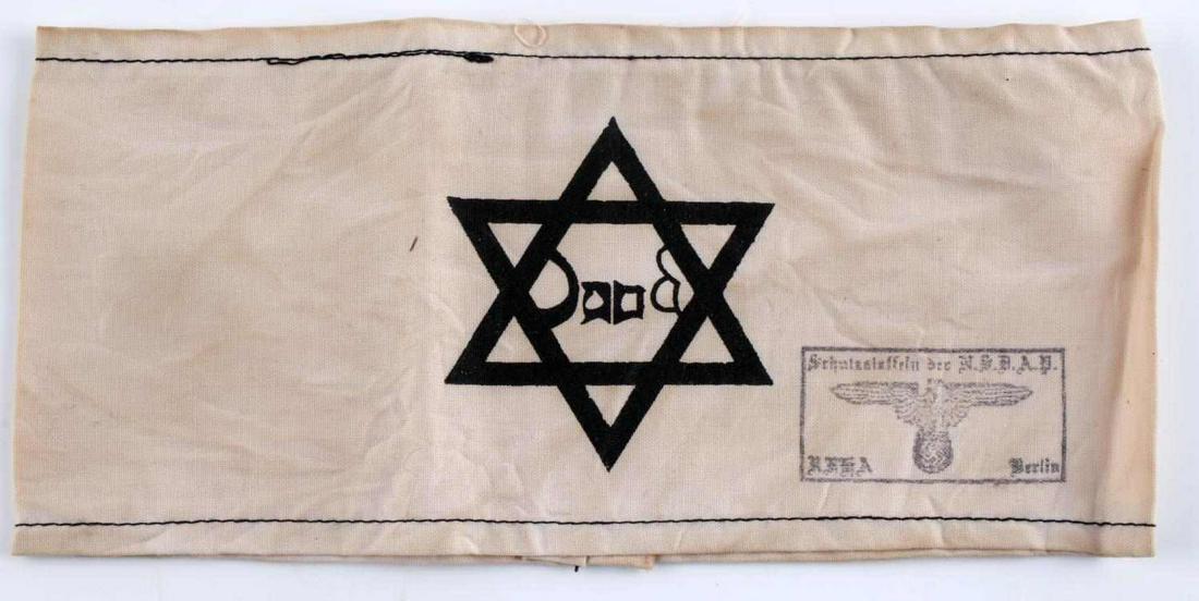 WWII GERMAN THIRD REICH JEWISH STAR CAMP ARMBAND: German WWII Jewish Star Concentration Camp Arm Band. Measures 8 3/8” wide by 3 3/4" wide. The front shows a Jewish Star in the center with a Waffen SS eagle with German writing stamped on the lower 