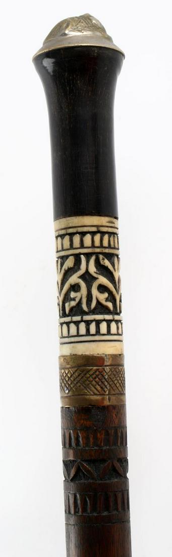 ANTIQUE CARVED WOOD AND BONE SWORD CANE WALKING: Metal feline pommel, hand-carved wood and bone handle, brass collar and ferrule. Blade measures 23 5/8 inches long with blood groove on each side, rounded tip. Some wear, overall good condition. Brass