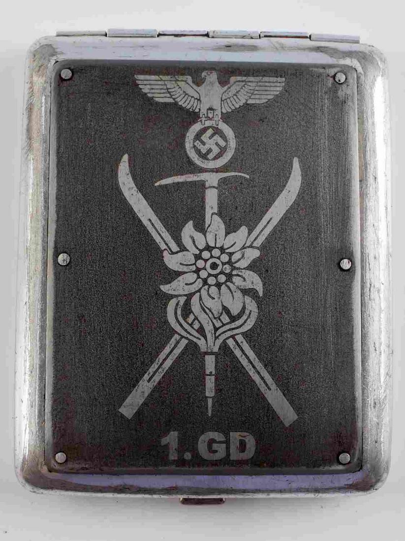 GERMAN WWII THIRD REICH HEER TROOPS CIGARETTE CASE: German Third Reich Heer Mountain Troops Cigarette Case. Silver finish with sand blasted eagle holding swastika emblem on front. Solid built latch, blue leather interior with strap to hold cigarettes. 