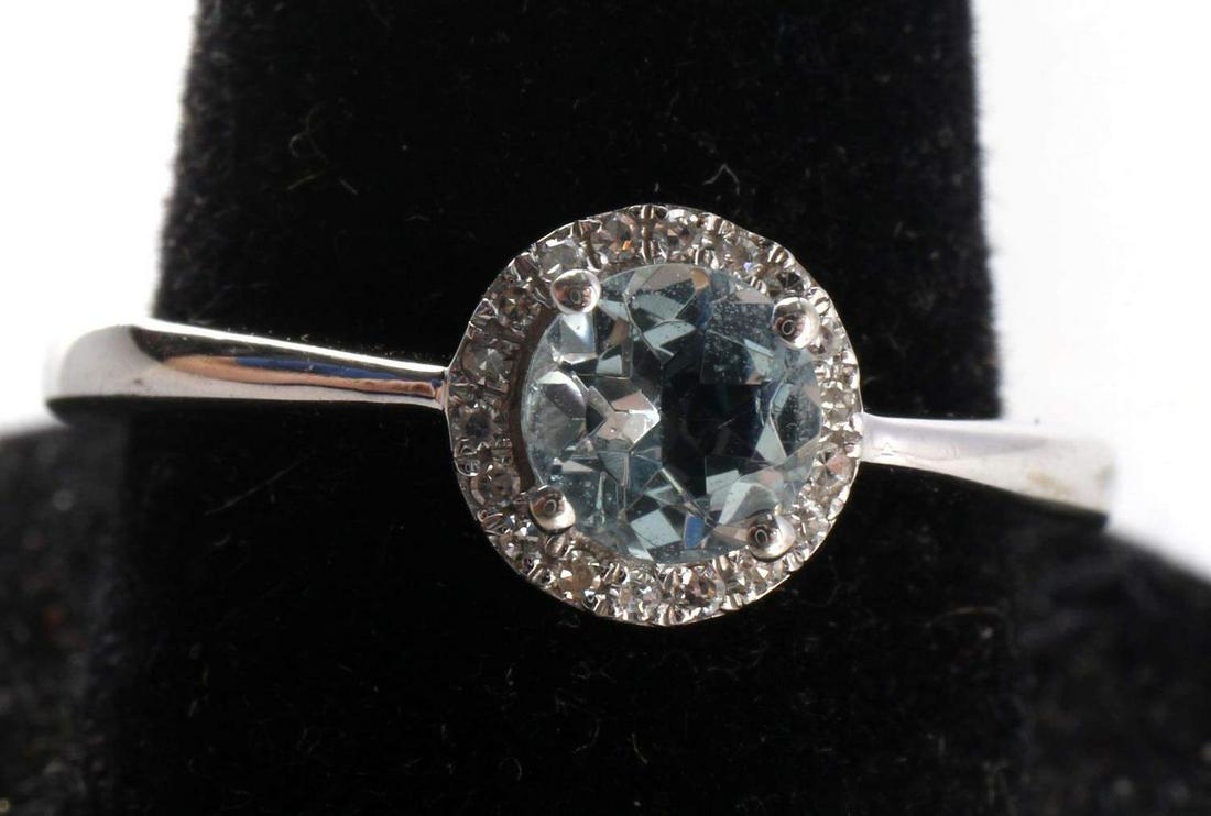 10 KT GOLD DIAMOND HALO AQUAMARINE SOLITAIRE RING: Hallmarked 10KT white gold with diamond halo around a 5mm round aquamarine gemstone. Total weight 2.4mg, size 7 1/2. This lot has a reserve.