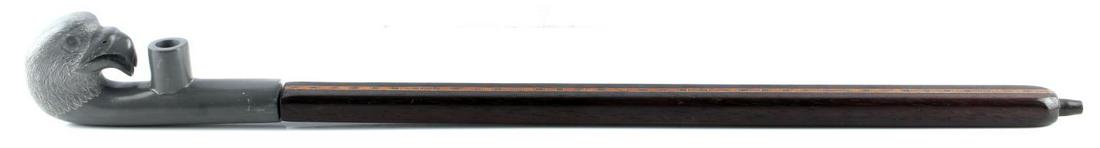 NATIVE AMERICAN PIPE W EAGLE HEAD & WOODEN STEM: Native American pipe with an eagle head carved out of gray pipe stone and beautiful marquetry style wooden stem. The eagle head is of newer construction while the wooden stem has some age to it, howev