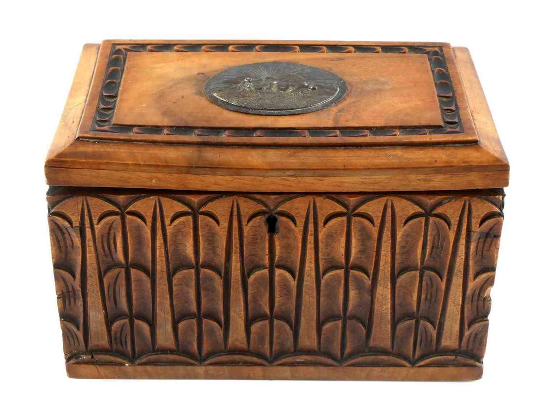 HAND CARVED TRINKET BOX W SILVER PLATE MEDALLION: Silver plate image depicts man and bulls plowing land, with sun and mountain in background. Carved border design and palm tree-like image throughout wooden box. Measures 7 3/8 X 5 X 4.5 inches. Missin