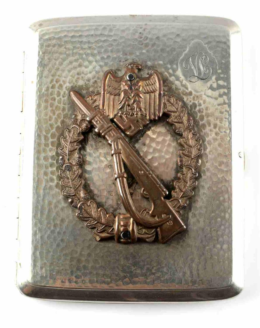 WWII GERMAN THIRD REICH CIGARETTE CASE GOLD: A German Third Reich cig case featuring an "LS" monogram, a Parteiadler, oak leaves, and a Kar98k on the front. Interior is gold colored. Measures 4 1/8 x 3 1/4. Very good condition.