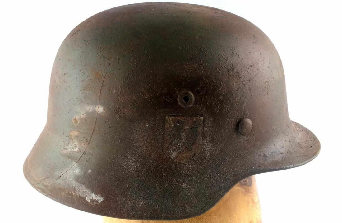 WWII GERMAN SS WAFFEN M35 NORMANDY CAMO HELMET: WWII German SS Waffen M-35 Normandy camouflage combat helmet. The exterior camouflage painted colors are green, red, and brown. SS Waffen runic decal to the right. Leather liner with aluminum band. In