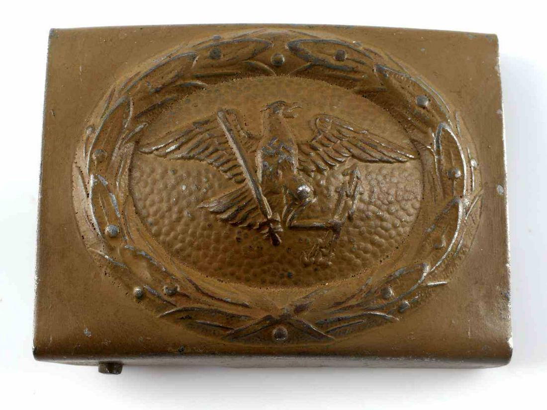 WWII GERMAN PRUSSIAN POLICE EM BELT BUCKLE: German WWII Prussian Police EM Belt Buckle. Measures 2 1/2” wide by 1 7/8” tall. There is a German eagle clutching a sword and arrows in his talons. There is a swastika in the center of his chest.