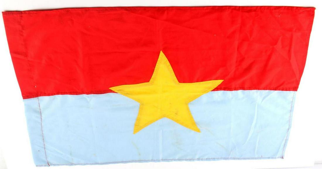 VIETNAM ERA VIET CONG VC COMBAT BATTLE FLAG: Vietnam Era Viet Cong VC Combat Battle Flag. Measures 29 inches wide by 20 1/8 inches tall. Shows a yellow five armed star in the center of a blue and red rectangle flag. Three piece machine sewn cott