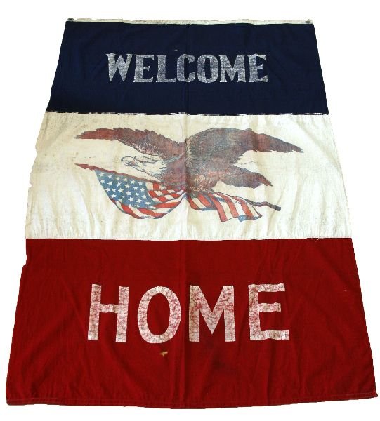 WWI US MILITARY "WELCOME HOME" FLAG: A printed, 3 piece cotton flag, 33 x 58 inches, made by Reliance. Some moth and print is age worn.