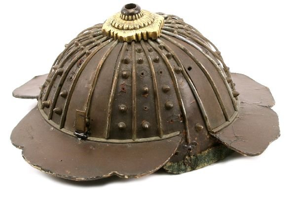JAPANESE SAMURAI HELMET KABUTO: Momoyama period (1573-1603) Kabuto. Lacquered paper skull overlayed with metal plates, ribs, and rivets (some absent). The top crown has brass (Mon) holder, muslin liner with leather loops (1 absent).