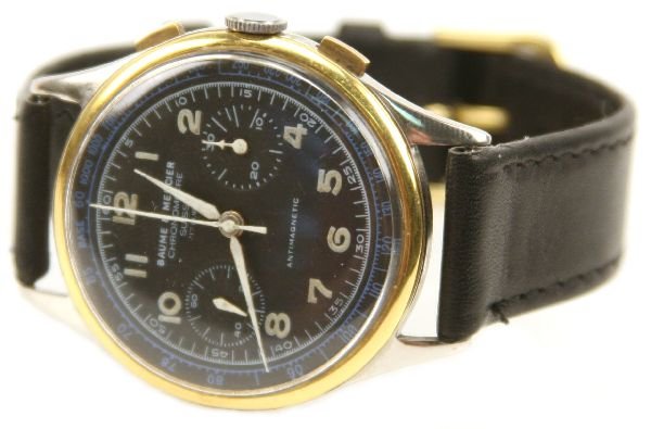 VINTAGE BAUME & MERCIER CHRONOMETRE WRISTWATCH: 38mm circular, gold rimmed bezel and stainless steel back. Black dial with sunken auxiliary second hand and stop watch . Properly marked. Slightly curved crystal. 18mm "cardinal" leather band.