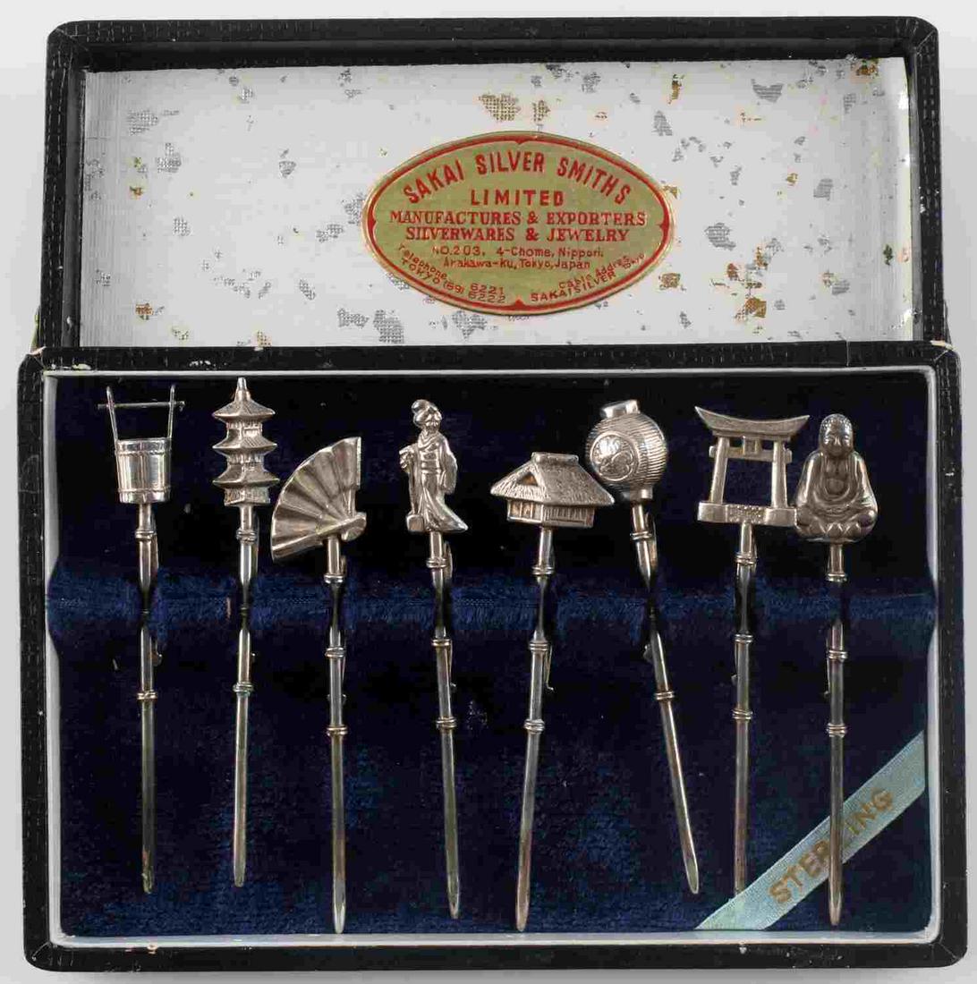 8 VINTAGE JAPAN SAKAI SILVERSMITHS STERLING PICKS: In box, 8 sterling silver Sakai Silversmiths Limited picks and skewers. Each pick shows a Japanese icon like a Buddha, Shinto gate. lantern, fan, temple, and more. Pick marked "STERLING JAPAN". Box sh