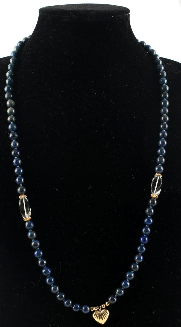 14 KT GOLD LAPIS LAZULI BEAD CRYSTAL NECKLACE: 30 inch Lapis lazuli, individually knotted, bead necklace with 14 karat gold heart pendant, crystal and gold accents. The beads measure 8-9mm, crystals measure 20 x9mm. Weighs 71.1 grams.