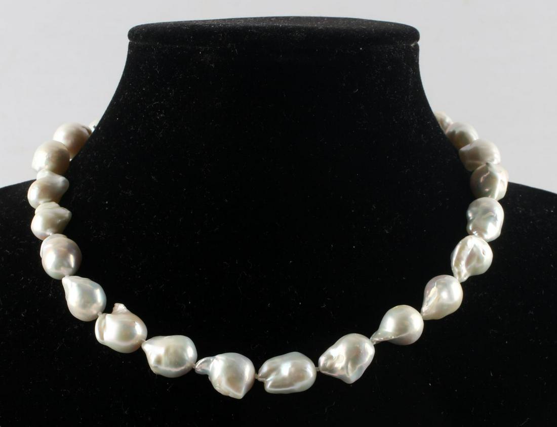 SOUTH SEA BAROQUE PEARL SILVER NECKLACE: 15 Inch Baroque pearl necklace. Pearls measure approx. 13-17mm. Sterling silver clasp. Free form with an iridescent sheen.