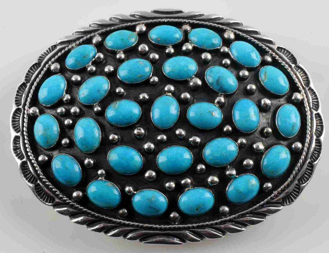 ANTIQUE STERLING SILVER AND TURQUOISE BELT BUCKLE: Antique sterling silver and turquoise belt buckle. 27 turquoise stone sets. with silver spheres and engraving to edge. Reverse: belt loop and hook and "T. HASTEEN STERLING" marked. Measures 3 1/2 X 2 