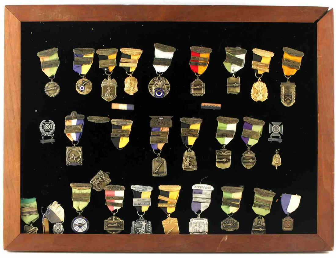 LOT OF 32 FRAMED SHARP SHOOTING SPORT MEDALS: Some of the medals include Stemmers Run club medals, W.R. Hearst Citizenship medals, Associated Gun Club medals, and more. Frame measures 18.5x24 inches and can be discarded to save on shipping.