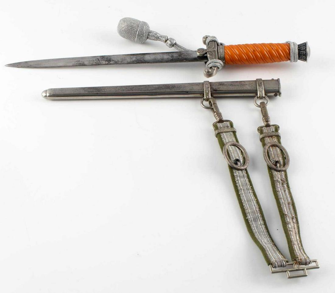 WWII GERMAN THIRD REICH OFFICERS HEER DAGGER: WWII German Army Heer officer's dagger with scabbard and hanger. Vertical oak leaf and acorn design to pommel. Bakelite orange grips. non fluorescing silver bullion knot tied correctly. Wehrmacht eagl