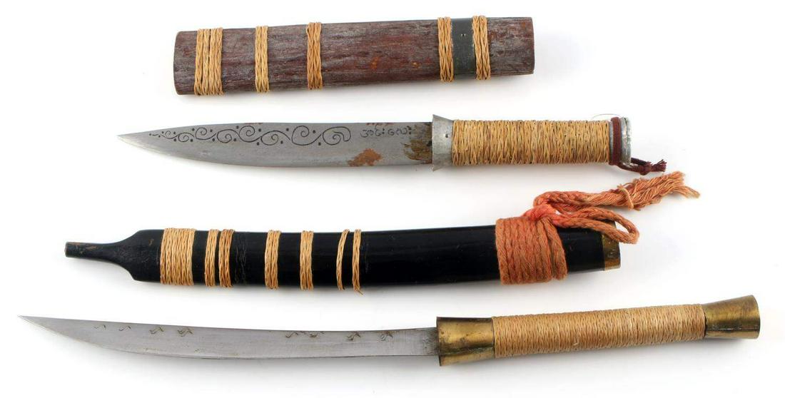 VINTAGE SOUTHEAST ASIAN KNIFE LOT WITH SCABBARDS: Two (2) South Pacific Asian knives with wooden scabbards. Both grips wrapped with a woven rope. Both blades have marking to both sides. Large blade 14 1/2 inches and smaller 10 1/2 inches. Both knives