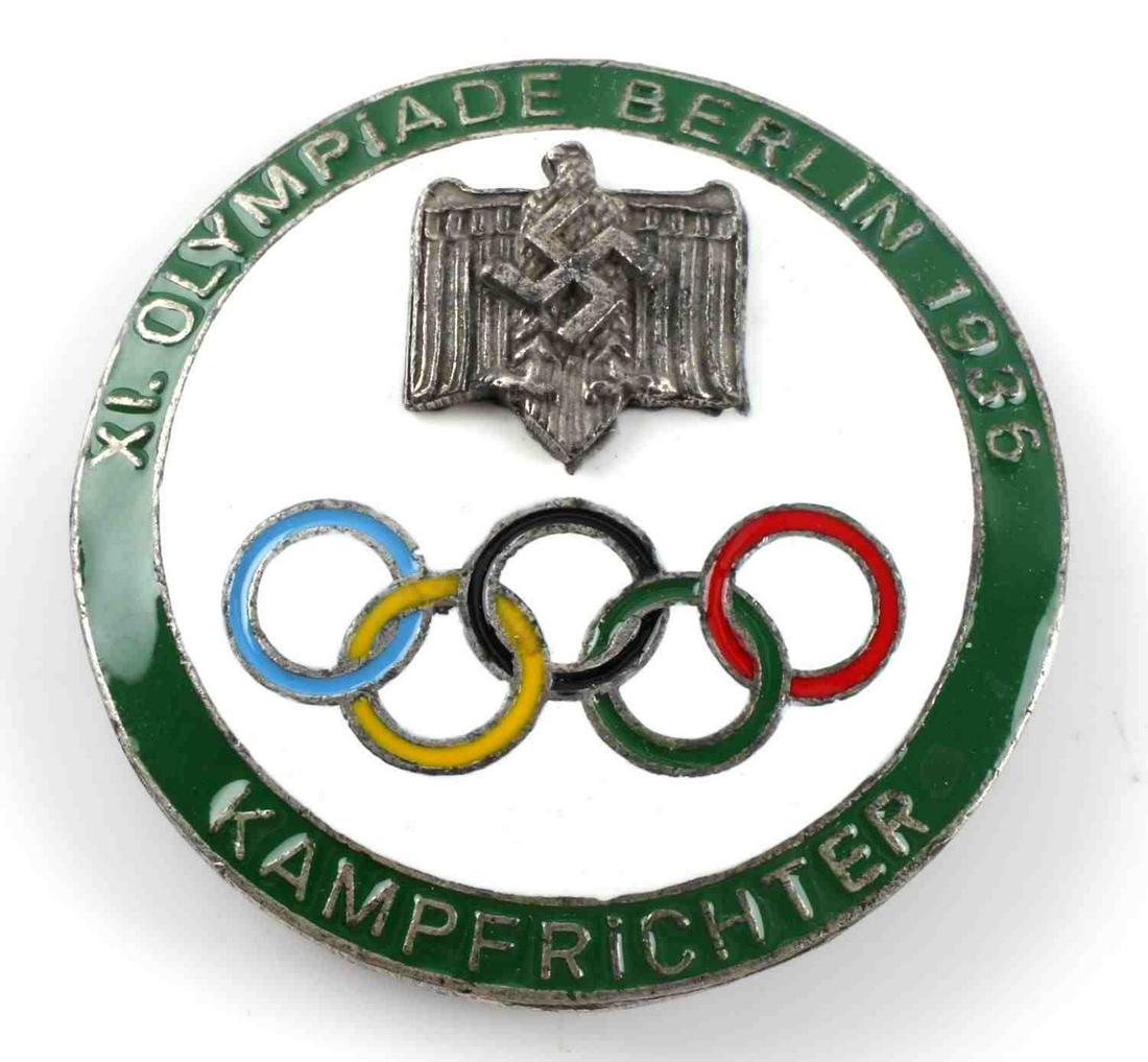 WWII GERMAN THIRD REICH BERLIN OLYMPICS BADGE: WWII German 1936 Berlin Olympics badge. Has a thin horizontal safety pin back. Measures approximately 2 inches in diameter. "Ges Gesch" maker's mark on the back. Very good condition overall. Unauthent