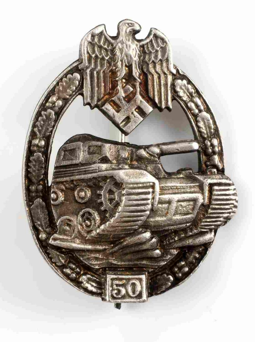 WWII GERMAN REICH HEER TANK BADGE FOR 50 ASSAULTS: WWII German Reich Heer tank badge for 50 assaults measuring 2 6/8 inches tall by 1 3/4 inches wide. Reverse side features a "SSW" mark, and a horizontal pin backing. Badge in overall good condition.0