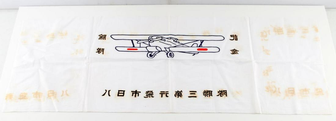 WWII IMPERIAL JAPANESE SMALL AIR FORCE FLAG: WWII imperial Japanese small air forces flag and headband, features a depiction of an airplane surrounded by characters from the Japanese language. Measures at 33 1/4 inches wide by 13 1/4 inches tall