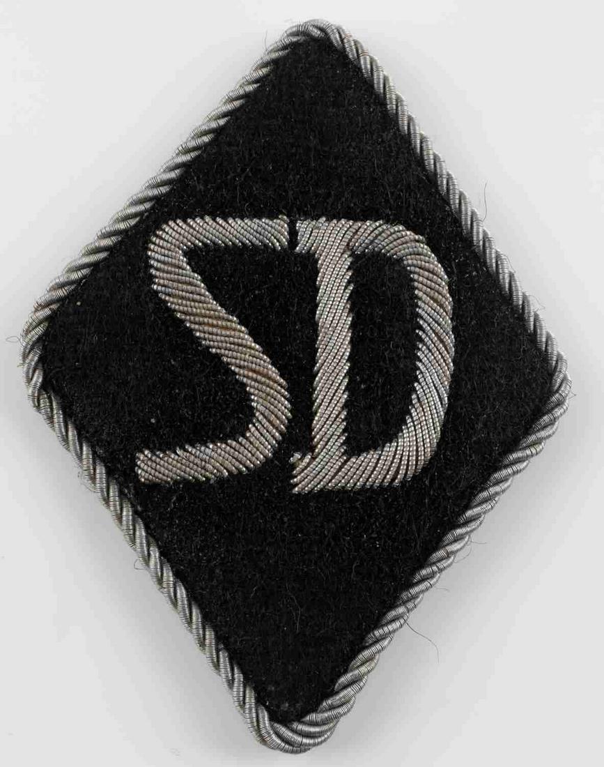 WWII GERMAN WAFFEN SS SD SLEEVE DIAMOND: WWII German Waffen SS SD sleeve diamond. Non-fluorescing silver bullion SD on black felt with twisted silver bullion edge. 3 X 2 1/4 inches. Very good condition.