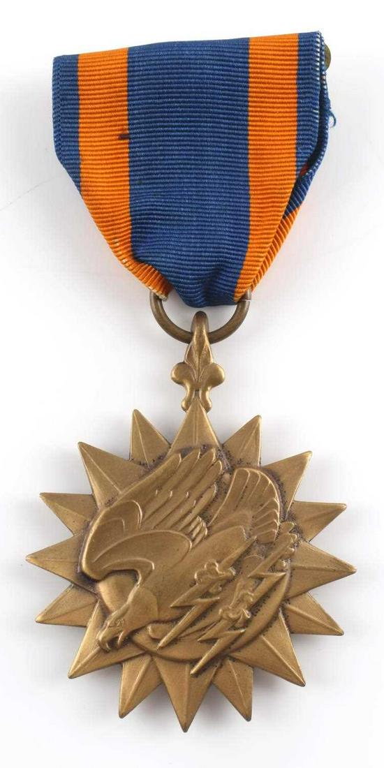 WWII NAMED USAF AIR MEDAL WITH SOME RESEARCH: Air medal with eagle design in relief, atop starburst, with blue and orange ribbon. Named 'James Duane Clark' on reverse. Few pieces of paper accompany lot about named person. Very good condition.