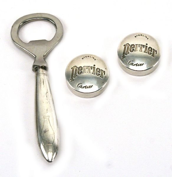 CARTIER STERLING SILVER BOTTLE OPENER W/ CAPS: A 5 inch Cartier sterling silver bottle opener with 2 sterling silver bottle caps marked Cartier Sterling Perrier. Total weight of lot is 2.02 ozt. Some tarnish.