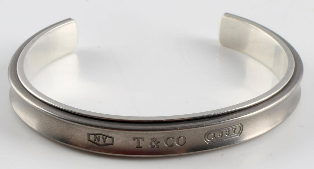TIFFANY & CO STERLING SILVER 1837 TITANIUM BANGLE: Authentic Tiffany & Co. 1837 sterling silver titanium cuff bangle. Measures 7.5 inches (190.5mm). Weighs 22.5 grams. Stamped Tiffany & Co. 925Ti on the inside of the bangle. Very good condition overal