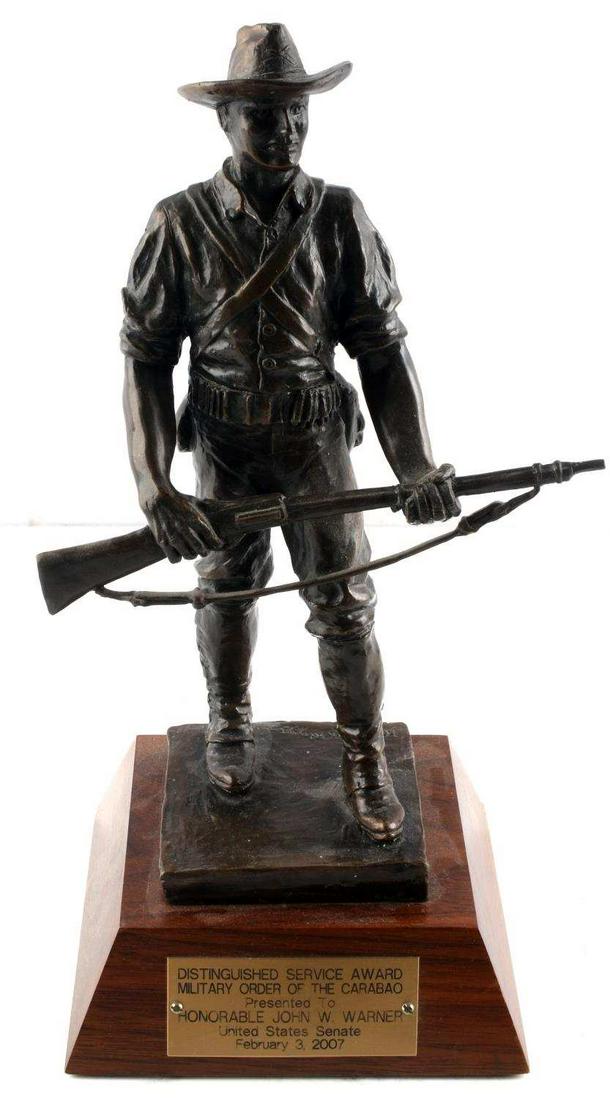 RIGGS BRONZE AWARD TO SENATOR JOHN W WARNER: Bronze soldier statuette created by Miriam Riggs and presented as The Distinguished Service Award Military Order of the Carabao presented to Honorable John W. Warner United States Senate February 3, 2