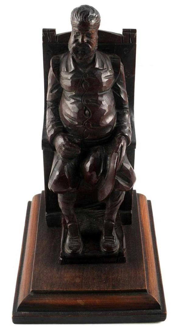 ANTIQUE BLACK FOREST CARVED WOOD POLITICAL FIGURE: Well executed antique Black Forest Germany carved wood figure sitting upon a heavy chair with a bag stuffed under it with 1000 on its side. 7 X 4 X 4 3/4 inch.