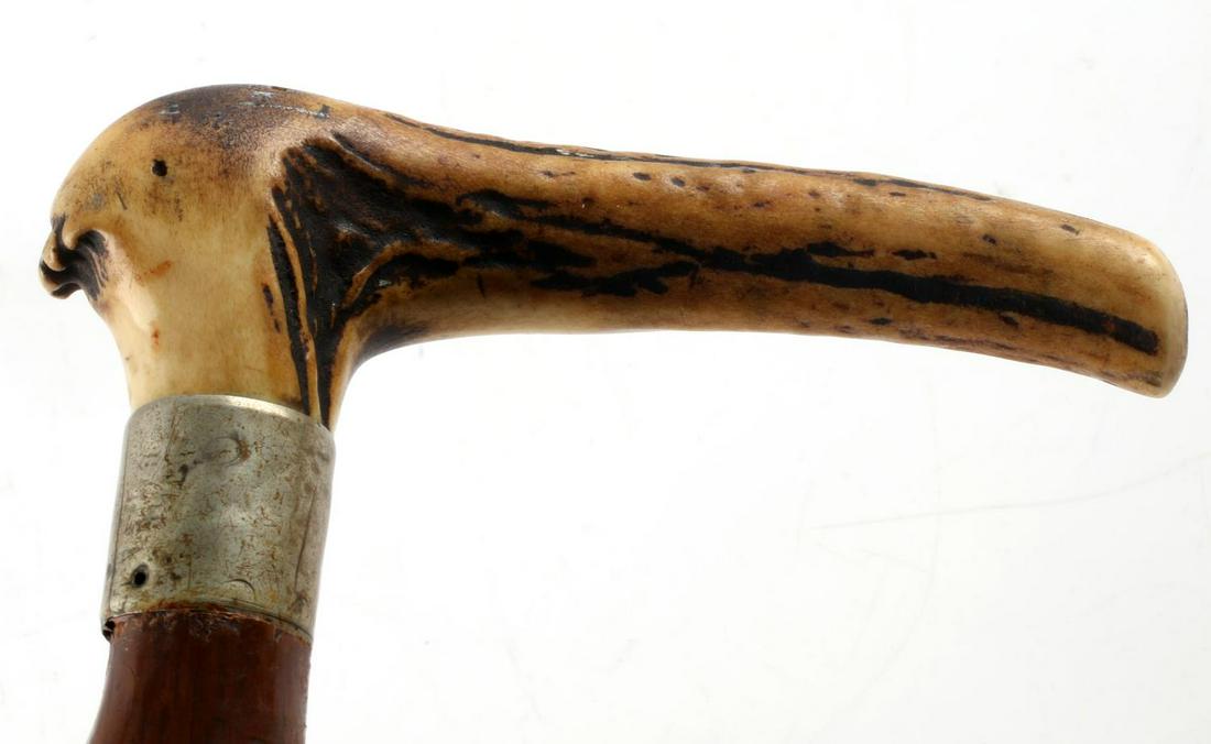 ANTIQUE WALKING STICK CANE WITH ANTLER HANDLE: Nice aged patina to to antler handle and wood shaft. Willow wood with coin silver wrap and rubber ferrule tip. Total length 34 1/2 inches.