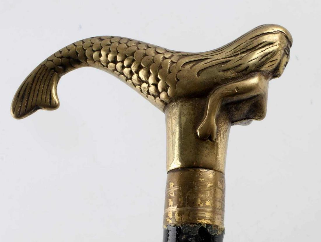 VINTAGE BRASS MERMAID SWORD CANE WALKING STICK: Brass Mermaid handle, painted black hardwood staff (use wear, nicks and chips to paint throughout), rubber ferrule, 18 inch stiletto style sword made in Taiwan. Total length 36 1/3 inches.