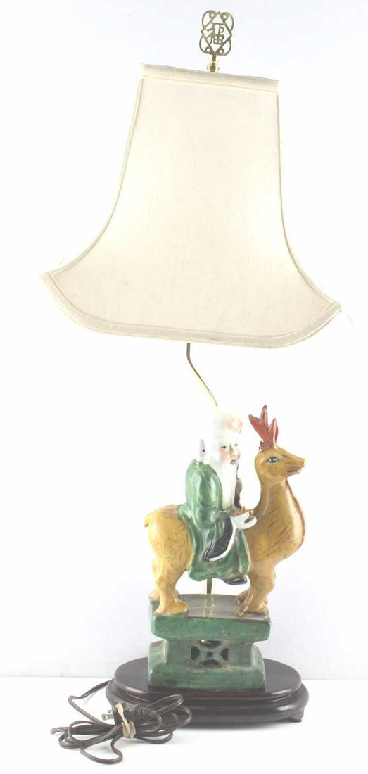 CHINESE PORCELAIN DEITY SHOUXING LAMP: Antique Chinese God of longevity, “Old Man of the South Pole” Shouxing riding a reindeer, porcelain figure married to newer lamp platform. Total height 31 inches, figure height 14 inches. Shade in