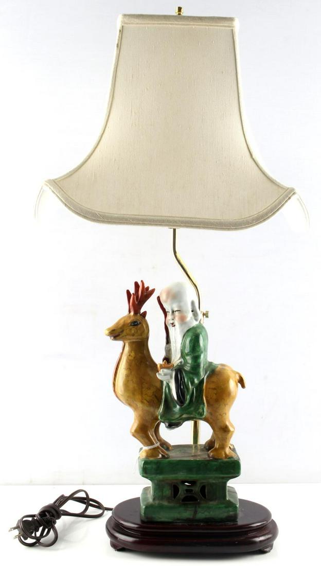 CHINESE PORCELAIN DEITY SHOUXING LAMP: Antique Chinese God of longevity, “Old Man of the South Pole” Shouxing riding a reindeer, porcelain figure married to newer lamp platform. Total height 31 inches, figure height 14 inches. Shade in