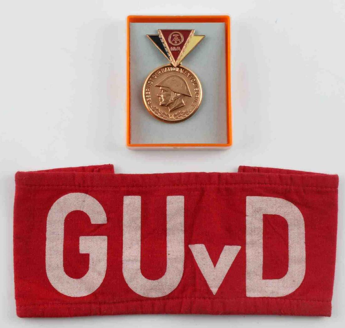 POST WWII EASTERN GERMAN MEDALS AND ARMBAND: Eastern German NVA medal, Reservist Der Nationalen Volksarmee, and a GUVD arm band. Very good condition. Measurements range 1 - 7 1/2 inches.
