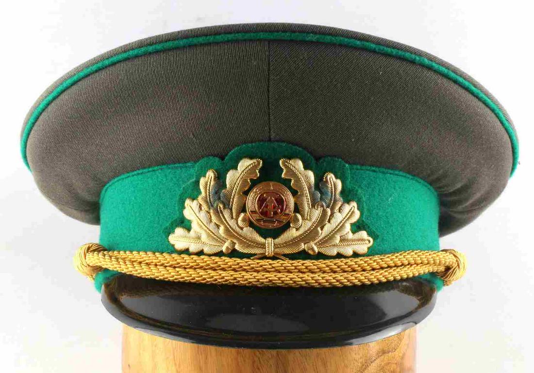 EAST GERMAN NVA ARMY GENERAL PEAKED VISOR CAP: East German NVA Army general peaked visor cap. Size 58. "NVA 1856 D" marked on the inside of the cap. Some slight discoloration to the insignia on the front but overall good condition.