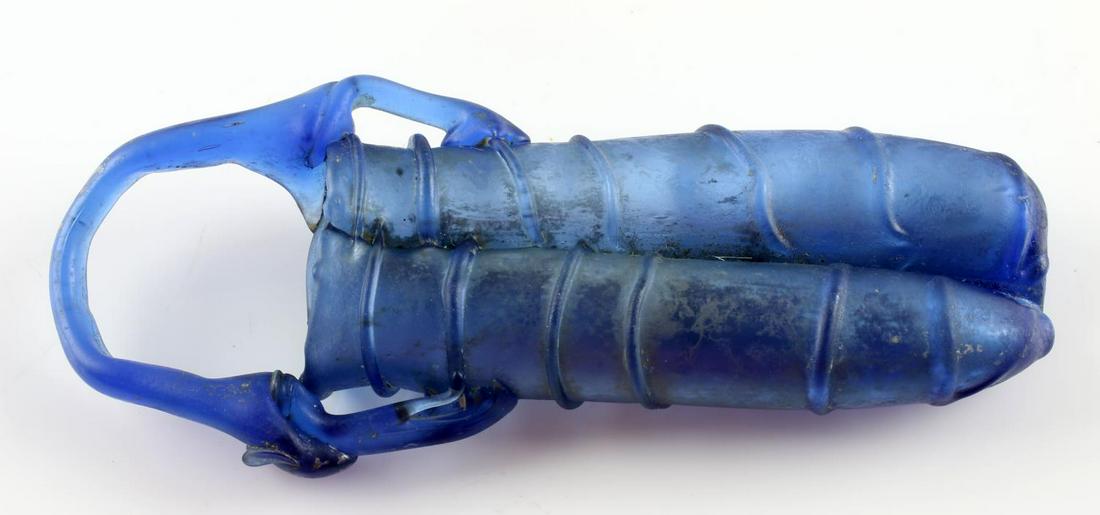 ANCIENT ROMAN DOUBLE UNGUENTARIUM GLASS FLASK: Ancient Roman unguentarium, also known as a balsamarium, and lacrimarium. Beautiful brilliant blue tone with ribbed surface and handle for easy carry. Interior features possible ancient contents for c