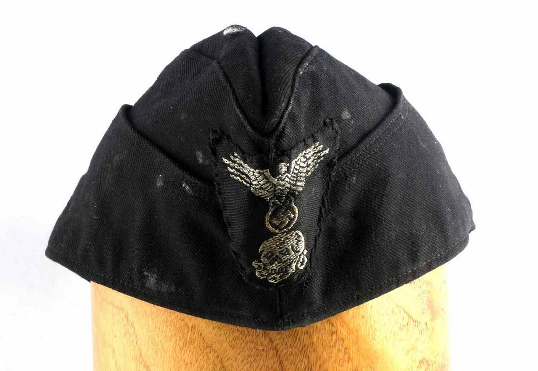 WWII GERMAN REICH OVERSEAS PANZER TOTENKOPF CAP: WWII German Reich overseas panzer totenkopf cap with "SS" eagle and totenkopf patch on front of cap, features tag inside with stitching that does fluoresce and has been stamped over.