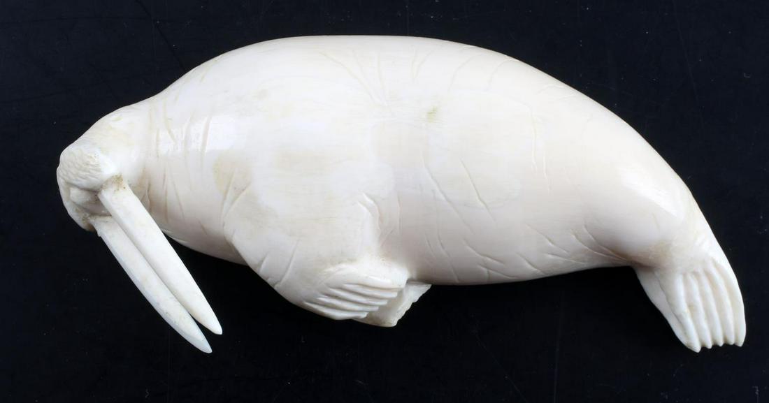 INUIT ESKIMO CARVED IVORY WALRUS FIGURE CARVING: Measures 4.5 inches long. Very good condition. Sticker at bottom reads 'Larry Kaua.' Please know your state's laws prior to bidding. Cannot ship to some states, nor international.