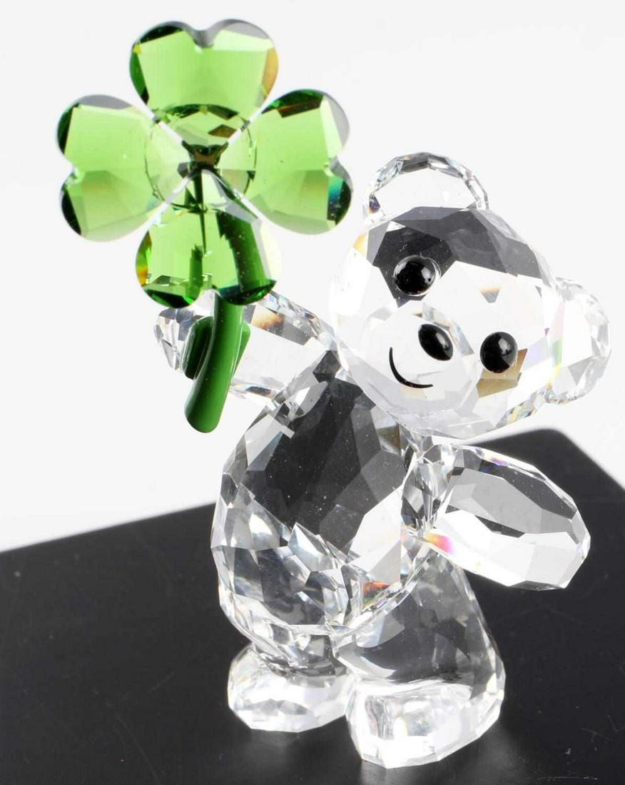 SWAROVSKI CRYSTAL KRIS BEAR LUCKY CHARM FIGURE: Kris Bear collection piece with 537 sparkling facets, the design shows a clear crystal Kris Bear holding a lucky clover in vibrant green crystal with a green lacquered metal stem. Size: 2 1/8 X 1 1/2