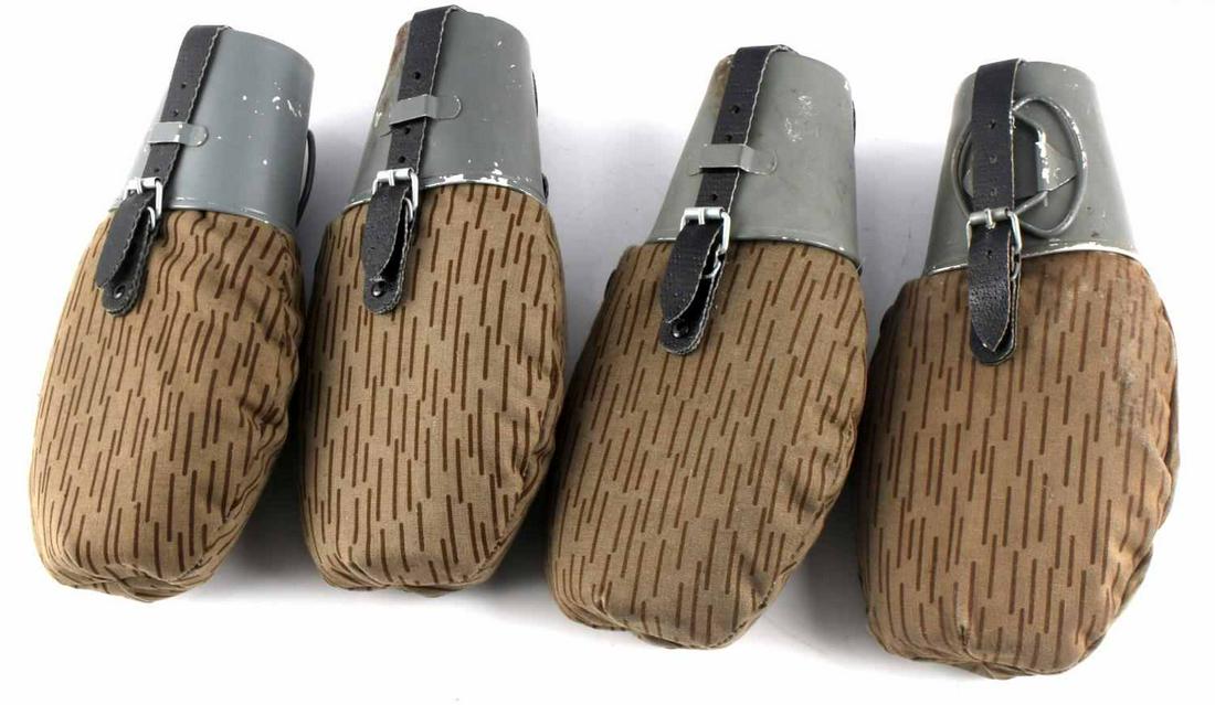 EAST GERMAN ARMY CANTEEN LOT OF 4: Plastic canteens with cloth cover, aluminum cups, and leather straps. Measure 9.5 inches long. Very good condition.