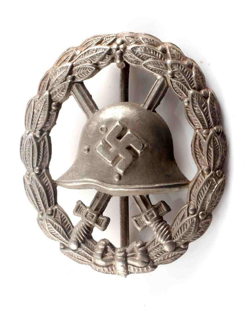 WWII GERMAN SILVER CONDOR LEGION WOUND BADGE: WWII German silver Condor Legion 1st type. Stamped with cut out center. Helmet with swastika to center with sword behind surrounded by oak leaf wreath. Thin vertical pin with 'c' catch. 1.75 X 1.50 in