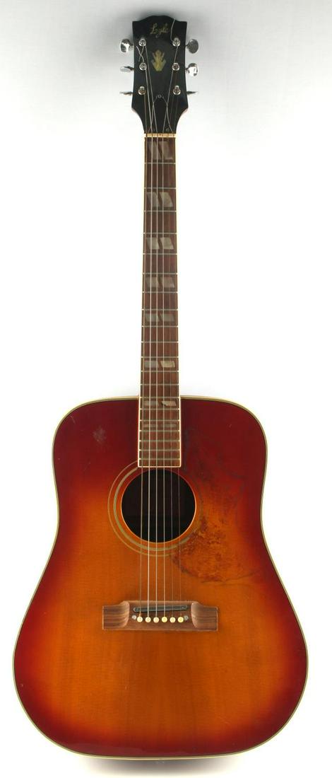 LYLE MODEL 680 L ACOUSTIC GIBSON BIRD GUITAR: A vintage Lyle model 680-L acoustic guitar that caused Gibson to form a lawsuit against Lyle for copyright infringement on the Gibson Hummingbird acoustic. Original bridge has been replaced with a met