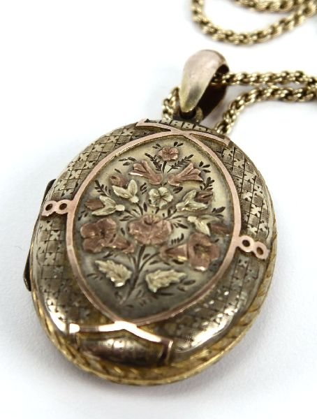 FLORAL GOLD FILLED LOCKET PENDANT W/ 14K CHAIN: FLORAL GOLD FILLED LOCKET PENDANT W/ 14K CHAIN A lovely antique floral motif gold filled locket pendant with photographs on an 18 inch 14K yellow gold chain. Chain has a broken clasp and weighs 8.6g. 